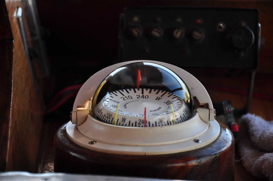 Close-up of a vintage compass on a wooden boat dashboard in Tigre, Argentina.
